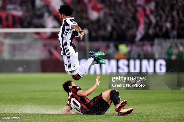 Juan Cuadrado of Juventus is challenged by Hakan Calhanoglu of Milan during the TIM Cup - Coppa Italia final match between Juventus and AC Milan at...