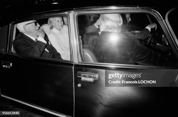 Jean Gabin et Michèle Morgan quittent une soirée en compagnie de Gérard Oury en Citroën DS Pallas à Paris en avril 1976, France.