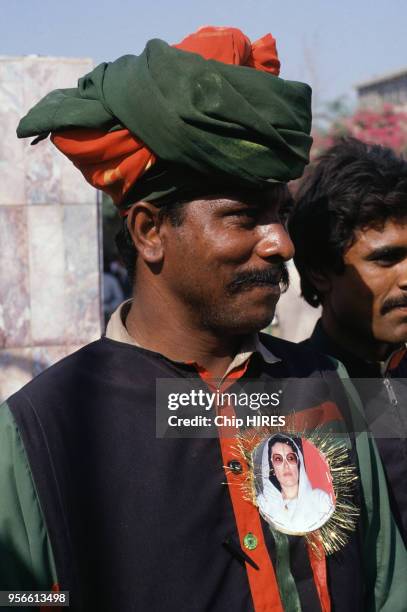 Homme portant une photo de Benazir Bhutto en novembre 1988 au Pakistan.