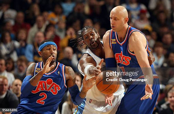 Zydrunas Ilgauskas of the Cleveland Cavaliers dishes off the ball to Mo Williams as Nene of the Denver Nuggets defends during NBA action at Pepsi...
