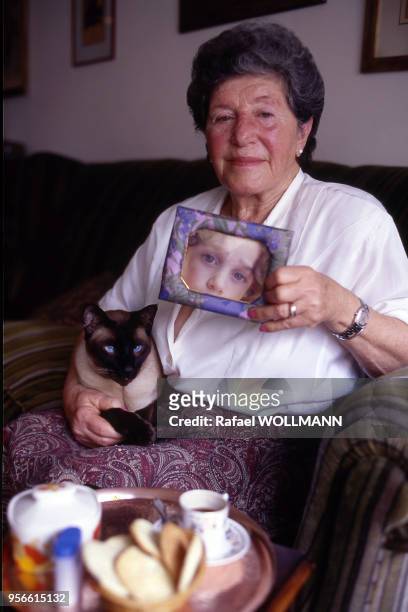 Femme membre des ?Mères de la place de Mai? posant avec une photo de son enfant disparu pendant la dictature en Argentine.