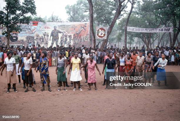 Militantes de l'U.N.I.T.A devant une affiche montrant Jonas Savimbi en février 1985 en Angola.