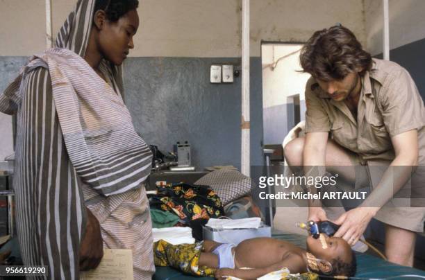 Soldat français soignant un enfant avec sa mère dans un hôpital en avril 1980 au Tchad.
