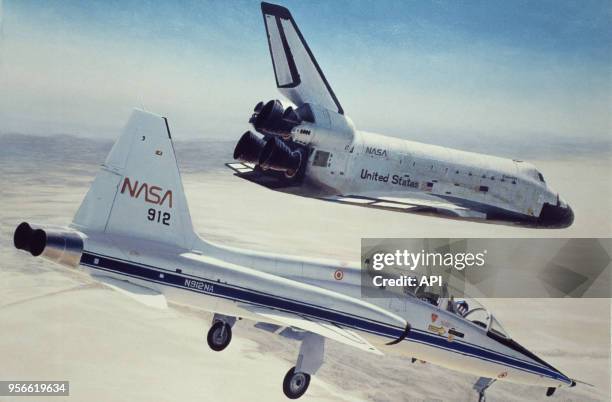 Atterrissage de la navette Columbia accompagnée d'un avion de chasse.