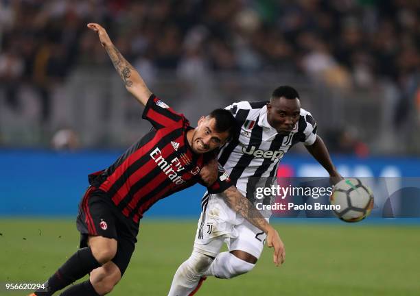 Kwadwo Asamoah of Juventus competes for the ball with Fernandez Suso of AC Milan during the TIM Cup Final between Juventus and AC Milan at Stadio...