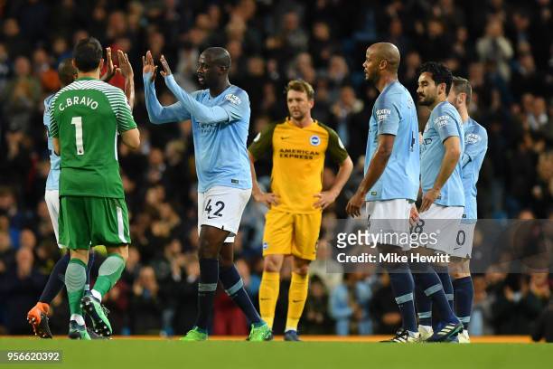 Yaya Toure of Manchester City is congratulated by Fernandinho of Manchester City and Claudio Bravo of Manchester City as he is substituted during the...