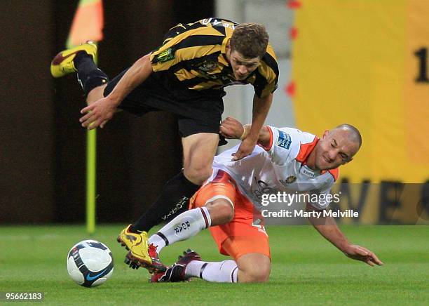 Tony Lochhead of the Phoenix gets tackled by Ivan Franjic of the Roar during the round 22 A-League match between the Wellington Phoenix and the...