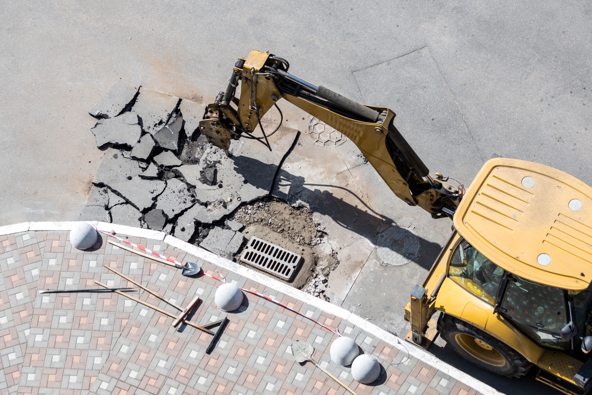 Big jackhammer drill drilling road.Heavy machinery crushing asphalt for stormwater drain repair Big jackhammer drill drilling road.Heavy machinery crushing asphalt for stormwater drain repair