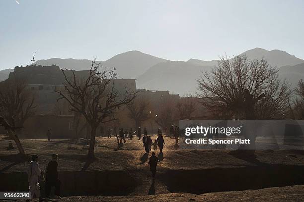 Residents walk in the village of Pushtay where a US Army Provincial Reconstruction Team made a visit on January 9, 2010 in Pushtay, Afghanistan....