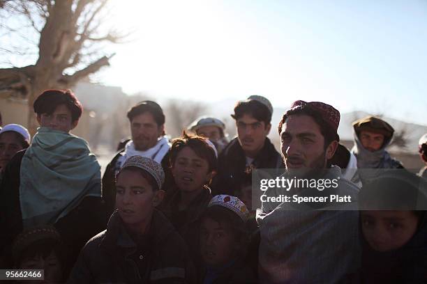 Residents listen to US Army soldiers from a Provincial Reconstruction Team in the village of Pushtay January 9, 2010 in Pushtay, Afghanistan....