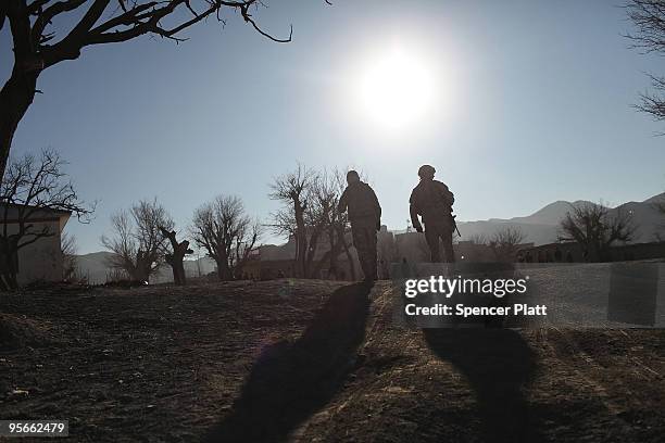 Army soldier an a Afghan interpreter with a Provincial Reconstruction Team enter the village of Pushtay January 9, 2010 in Pushtay, Afghanistan....