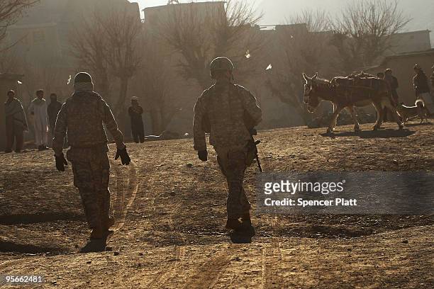 Army soldier an a Afghan interpreter with a Provincial Reconstruction Team enter the village of Pushtay January 9, 2010 in Pushtay, Afghanistan....