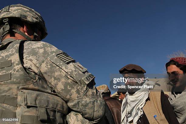 Kimo Bandmann of Utah with the 405 Civil Affairs Unit and part of a Provincial Reconstruction Team ,speaks with residents during a visit to the...