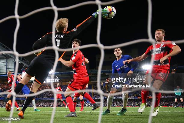 Jonas Lossl of Huddersfield Town makes a save as Alvaro Morata of Chelsea and Laurent Depoitre of Huddersfield Town looks on during the Premier...