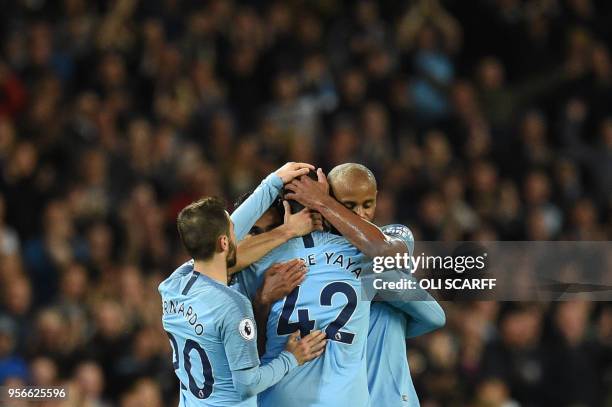 Manchester City's Ivorian midfielder Yaya Toure is embraced by Manchester City's Belgian defender Vincent Kompany , Manchester City's German...