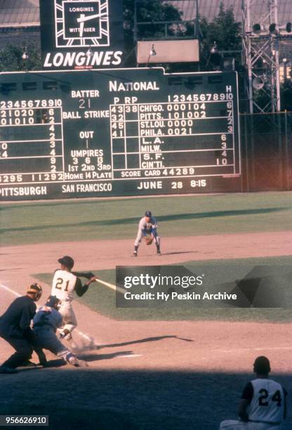 Roberto Clemente of the Pittsburgh Pirates checks his swing as third baseman Ron Santo and catcher El Tappe of the Chicago Cubs defend as umpire Ed...