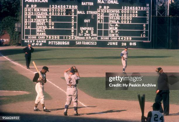 Roberto Clemente of the Pittsburgh Pirates steps into the batters box as third baseman Ron Santo and catcher El Tappe of the Chicago Cubs get ready...