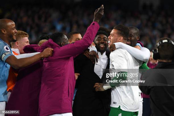 Yaya Toure of Manchester City is jumped on by his teammates and his brother Kolo Toure after the Premier League match between Manchester City and...