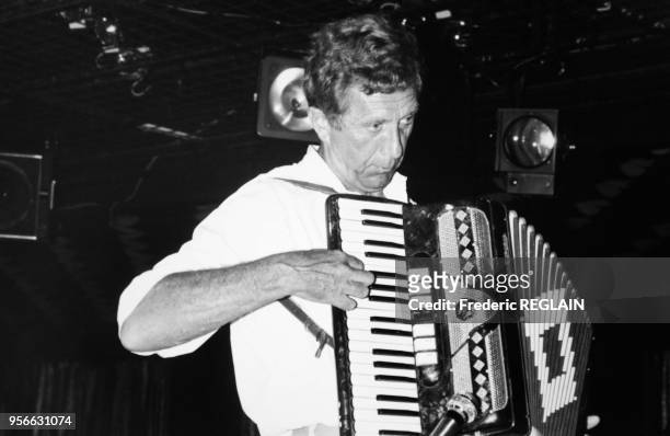 Le journaliste Bertrand Poirot-Delpech jouant de l'accordéon à bord d'un bateau lors d'une croisière dans la mer des Caraïbes, le 13 janvier 1987.