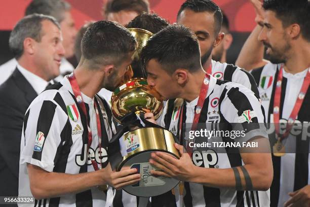 Juventus midfielder from Italy Miralem Pjanic and Juventus' forward from Argentina Paulo Dybala kiss the trophy after winning the Italian Tim Cup...