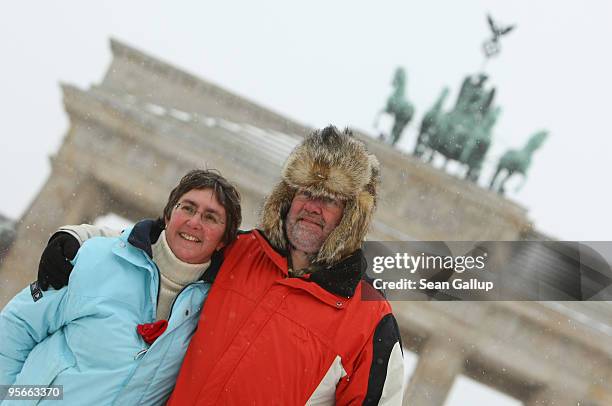 Tourists pose for a snapshot bundled against the cold at the Brandenburg Gate on January 9, 2010 in Berlin, Germany. A snowstorm is moving across...