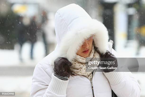 Young woman walks bundled against the cold along Kurfuerstendamm street on January 9, 2010 in Berlin, Germany. A snowstorm is moving across Germany...