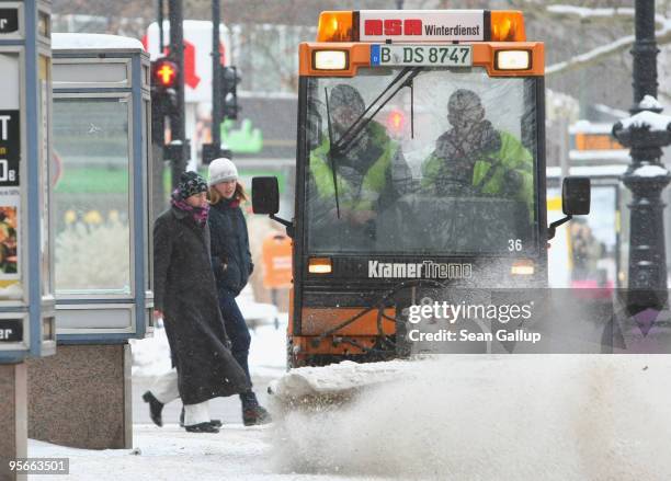 Workers clear freshly-fallen snow along Kurfuerstendamm street on January 9, 2010 in Berlin, Germany. A snowstorm is moving across Germany and is...