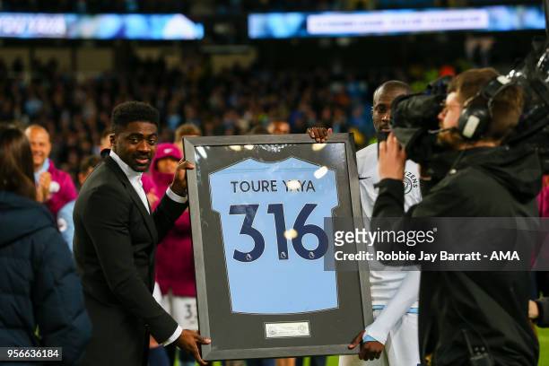 Kolo Toure awards Yaya Toure of Manchester City with a shirt after he makes his final appearance for the club during the Premier League match between...