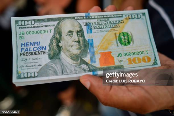 Man holds election propaganda -simulating dollar bills- of Venezuelan opposition presidential candidate Henri Falcon , in Caracas, Venezuela, on May...