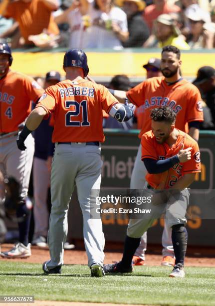 Derek Fisher of the Houston Astros is congratulated by Jose Altuve after he hit a home run in the seventh inning against the Oakland Athletics at...