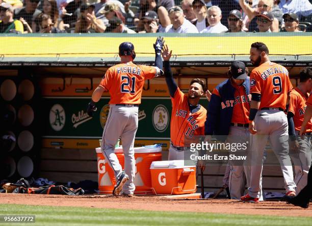 Derek Fisher of the Houston Astros is congratulated by Yuli Gurriel after he hit a home run in the seventh inning against the Oakland Athletics at...