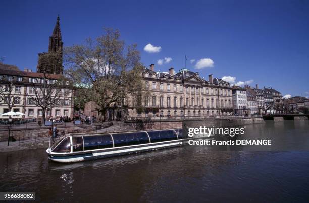 Bateau-mouche et façade du Palais Rohan donnant sur l'Ill en avril 1996 à Strasbourg, France.