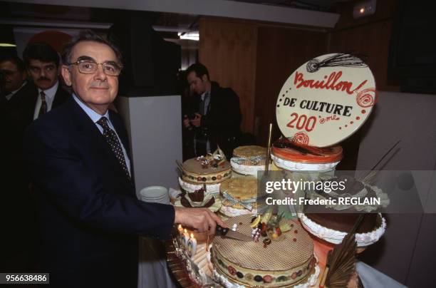 Animateur de télévision Bernard Pivot découpe le gâteau d'anniversaire pour la 200e émission de 'Bouillon de culture' en mars 1996 à Paris, France.