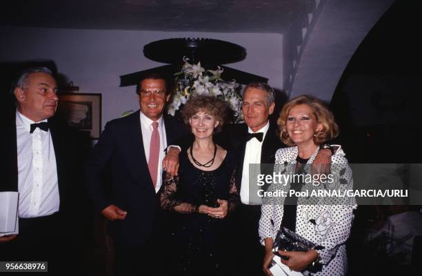 Roger Moore et Paul Newman et leurs épouses lors du Festival de Cannes en mai 1987, France.