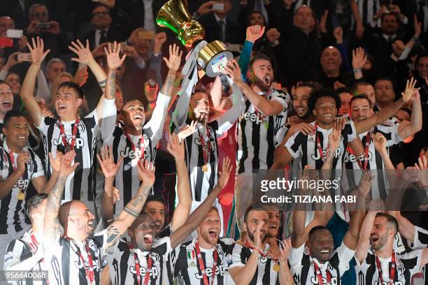 Juventus' players celebrate with the trophy at the end of the Italian Tim Cup final Juventus vs AC Milan at the Olympic stadium on May 9, 2018 in...