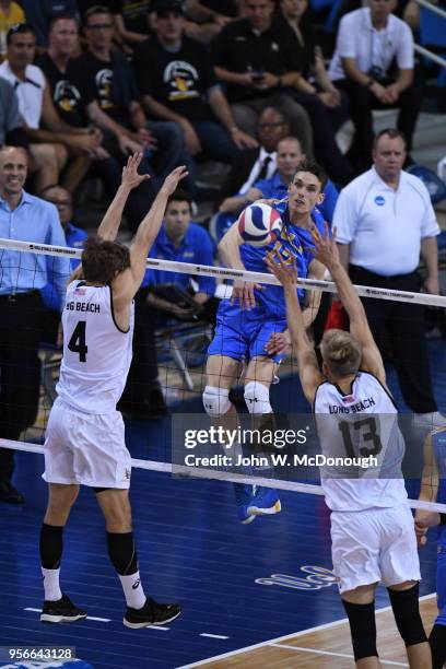 Christian Hessenauer of the UCLA Bruins spikes the ball past Simon Anderson of the Long Beach State 49ers during the Division 1 Men's Volleyball...