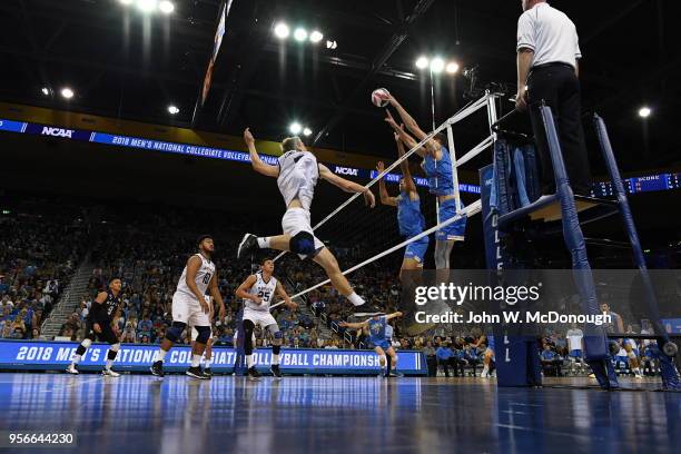 Daenan Gyimah and Jake Arnitz of the UCLA Bruins block a spike against Kyle Ensing of the Long Beach State 49ers during the Division 1 Men's...