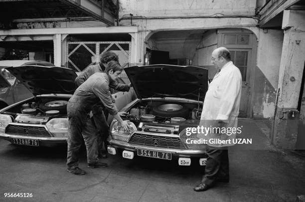 Droite Jean Chambrin, garagiste inventeur d'un moteur pour automobiles fonctionnant grâce à un mélange d'eau et d'alcool en octobre 1974 à Rouen,...