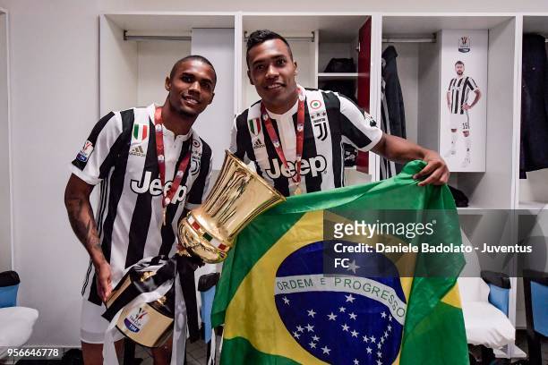 Douglas Costa and Alex Sandro of Juventus celebrate with the trophy after winning the TIM Cup Final between Juventus and AC Milan at Stadio Olimpico...