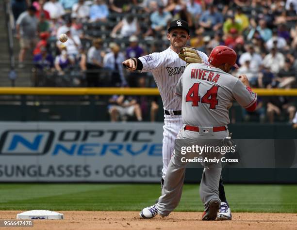 Colorado Rockies shortstop Trevor Story throws to first for a double play against Los Angeles Angels catcher Rene Rivera and Los Angeles Angels...