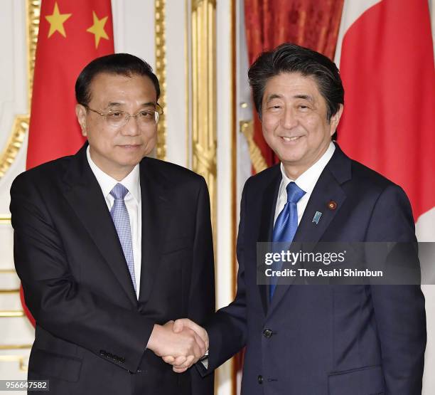 Chinese Premier Li Keqiang and Japanese Prime Minister Shinzo Abe shake hands during a joint press conference following bilateral meeting on the...