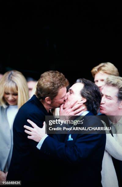 Johnny Hallyday embrasse Michel Sardou au mariage de ce dernier et Anne-Marie Perier le 11 octobre 1999 à Neuilly-sur-Seine, France.