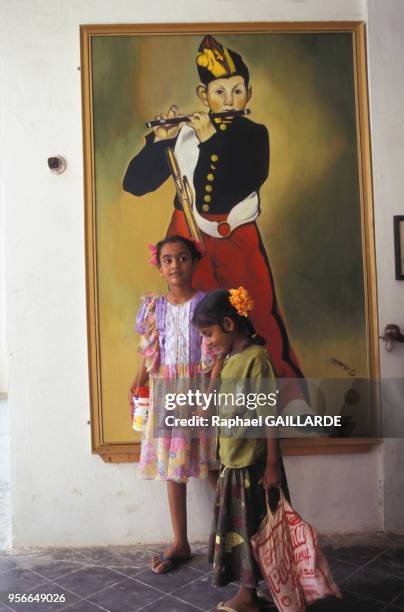 Deux petites filles au lycée français devant une reproduction du célèbre tableau de Manet, 'Le Fifre', juin 1997, Pondichéry, Inde.