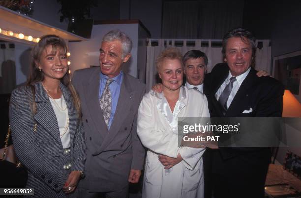 Jean-Paul Belmondo et son amie Natty, Guy Bedos et Alain Delon entourent Muriel Robin dans sa loge en novembre 1994 à Paris, France.