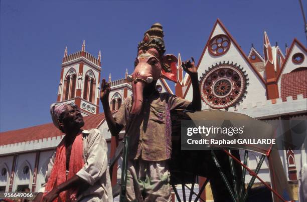 Un indien portant un masque du dieu hindou Ganesh pose devant l'Eglise du sacré coeur de Jésus, juin 1997, Pondichéry, Inde.