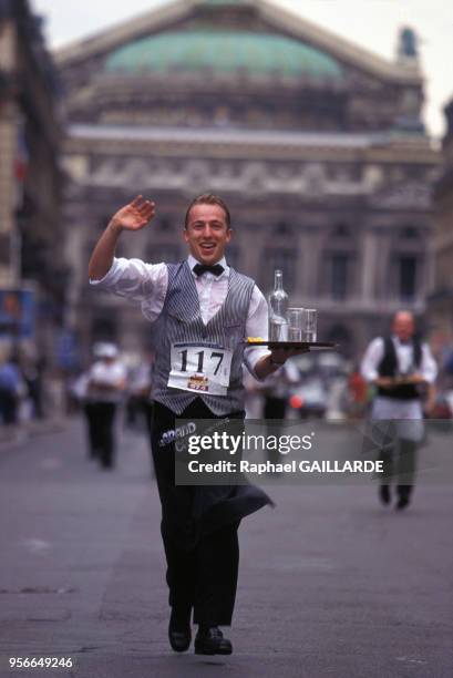 Un des participants à la course, tenant son plateau en équilibre, arrive avenue de l'Opéra, en juin 1997, Paris, France.