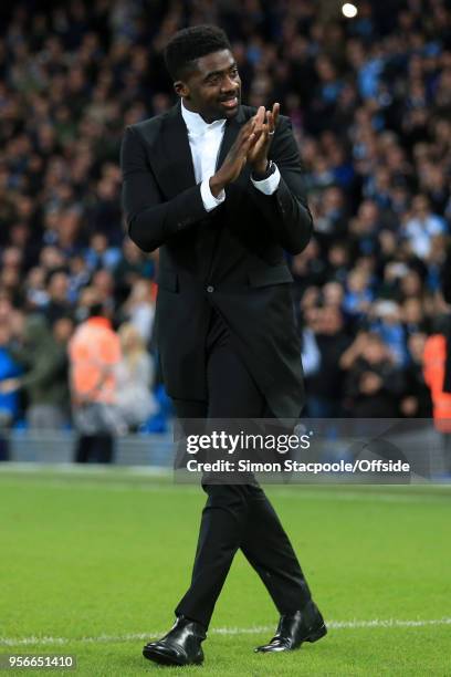 Former Man City player Kolo Toure walks onto the pitch to present brother Yaya Toure of Man City with a gift to mark his final game for the club...