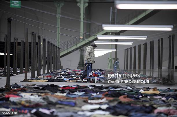 Worker arrives with clothes to complete on January 9, 2010 at the "Grand Palais" in Paris, the work of French artist Christian Boltanski for the...