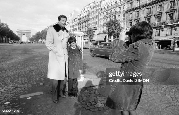 Acteur britannique Roger Moore et ses enafants sur les Champs-Elysées à Paris le 3 novembre 1974, France.