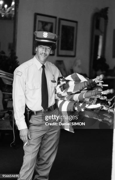 Un policier tenant des drapeaux américains sous son bras en avril 1976 à La Nouvelle-Orléans, Etats-Unis.